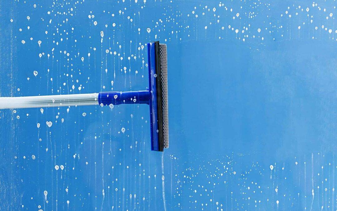Rubber squeegee cleans window. Clears a stripe of soaped window. Cleaning service concept.